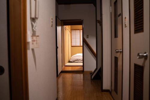 a hallway with a room with a bed in it at 泊まれる図書館 寄処 -yosuga- in Toyama