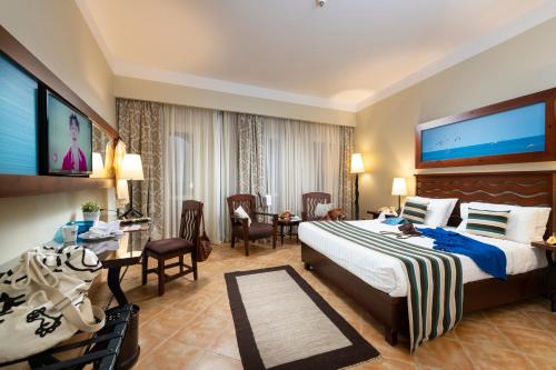 a hotel room with a bed and a table and chairs at Three Corners Ocean View El Gouna - Adults Only in Hurghada