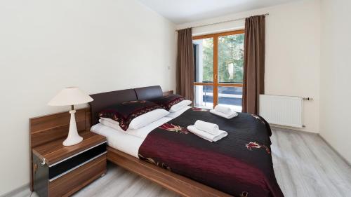 a bedroom with a bed with two towels on it at Apartamenty Sun & Snow Kościelisko Czajki in Kościelisko
