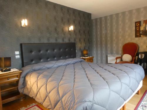 a bedroom with a large bed and two chairs at Chambres d'Hôtes La Balaguère in Cauterets