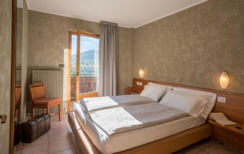 - une chambre avec un grand lit et un balcon dans l'établissement Residence Fior d'Alpe, à Valdidentro