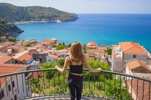 a woman standing on a balcony looking at the ocean at Best Western Hotel La Conchiglia in Palinuro