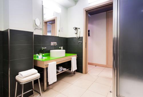 W łazience znajduje się zielona umywalka i lustro. w obiekcie Hotel Europa w mieście Latina