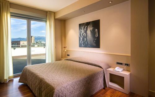 1 dormitorio con cama y ventana grande en Hotel Europa, en Latina