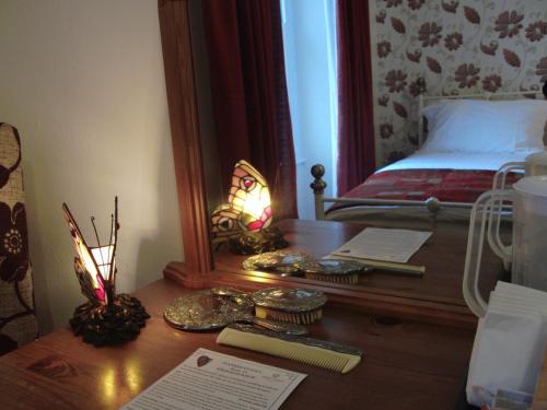 a desk with a mirror and a bed in a bedroom at Llanwrtyd Hall B&B Angelis Holistic Retreat in Llanwrtyd Wells