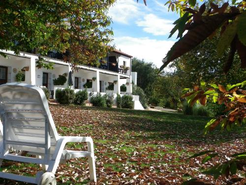 a white chair sitting in front of a house at Hotel Apartamento Rural Finca La Media Legua in Aracena