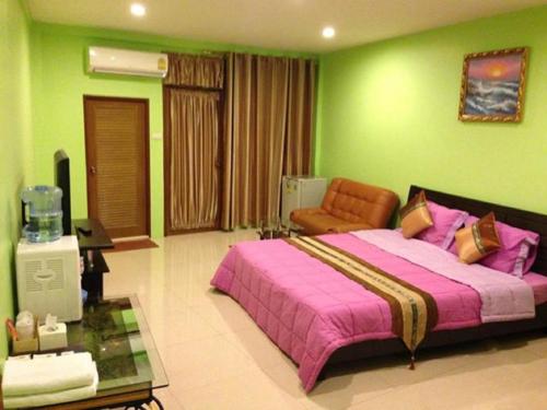 a bedroom with a large bed and a green wall at Penang Palace in Bangkok
