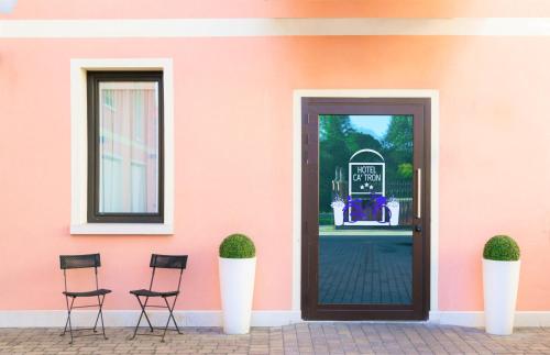 a pink building with chairs in front of a door at Hotel Ca' Tron in Dolo