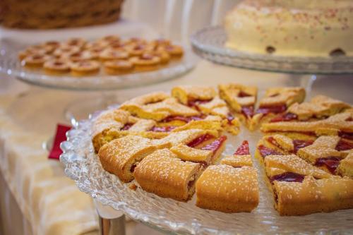 a table topped with pies and cakes on plates at Best Western Hotel La Conchiglia in Palinuro