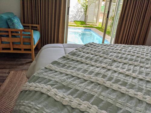 a bedroom with a bed with a view of a pool at Garten Hotel in El Zonte