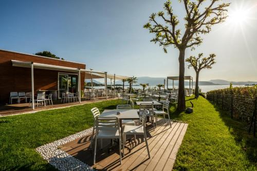 a restaurant with tables and chairs on the grass at Onda Blu Resort in Manerba del Garda