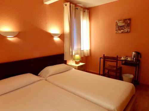 a bedroom with two white beds and a window at Hotel Roc de St Miquel & Apartment in Soldeu