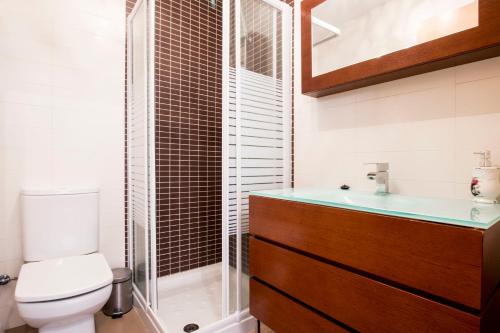 a bathroom with a toilet and a sink and a shower at Casa Rural Galana in La Puebla de Valverde