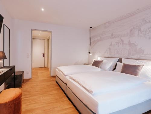 two beds in a white room with a painting on the wall at HAIMHAUSERS Hotel Garni in Haimhausen