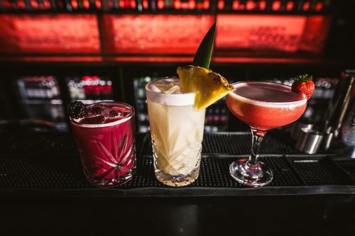 two cocktails sitting on a table in a bar at St Christopher's Inn Hammersmith in London