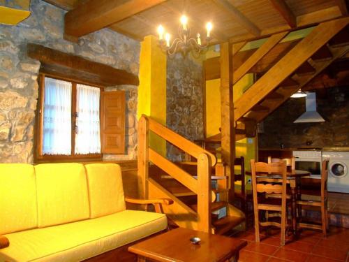 a living room with a yellow couch and a table at Las Casucas de Ason in Arredondo