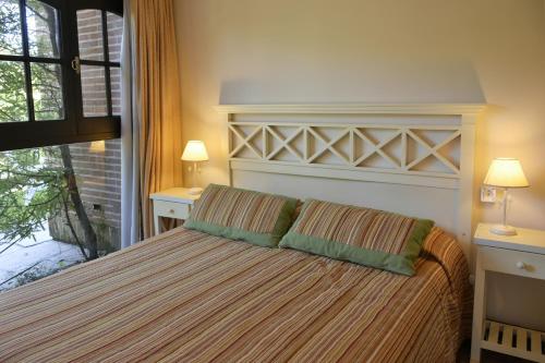 a bedroom with a large bed with two pillows at Apart Hotel Las Hadas Carilo in Carilo