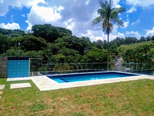 a villa with a swimming pool and a palm tree at Escondidinho da Serra in Serra Negra