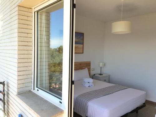 ein Schlafzimmer mit einem Bett und einem Fenster in der Unterkunft Aiguaneu S´Ermita in Blanes