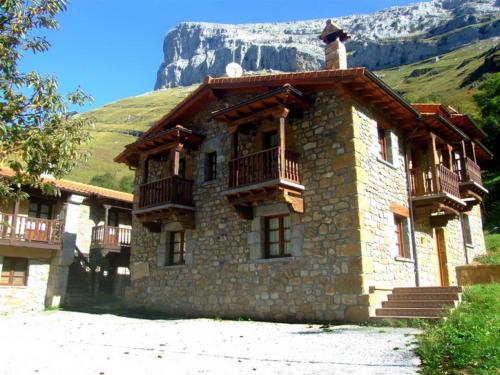 un gran edificio de piedra con balcones en una montaña en Las Casucas de Ason, en Arredondo