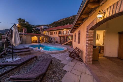 einen Hinterhof mit einem Pool und einem Haus in der Unterkunft Hacienda in Grižane