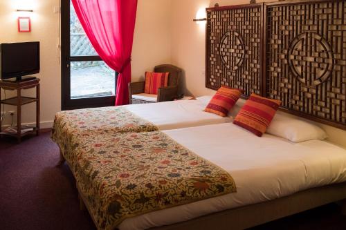 a hotel room with a bed and a window at La Chaumière Roz-Aven in Pont-Aven