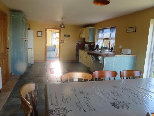 
a kitchen area with a table and chairs at BunkHouse - Letterfrack Farm in Letterfrack
