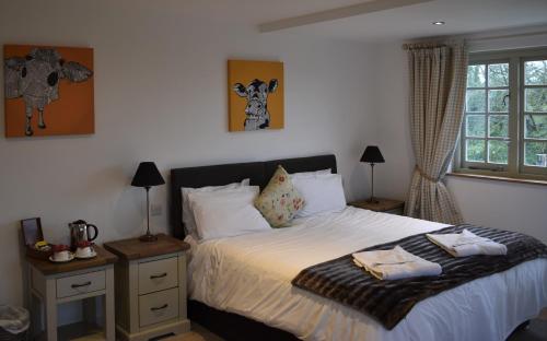 a bedroom with a bed with white sheets and a window at Three Horseshoes Country Inn in Barry
