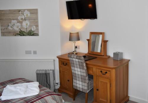 a bedroom with a desk with a mirror and a bed at Three Horseshoes Country Inn in Barry