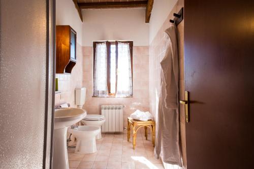 La salle de bains est pourvue d'un lavabo, de toilettes et d'une fenêtre. dans l'établissement BORGO MONTEMAGGIORE, à Rapolano Terme