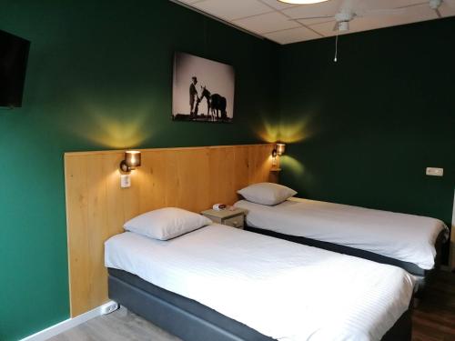 two beds in a room with green walls at Hotel Lemmenhof in Ell