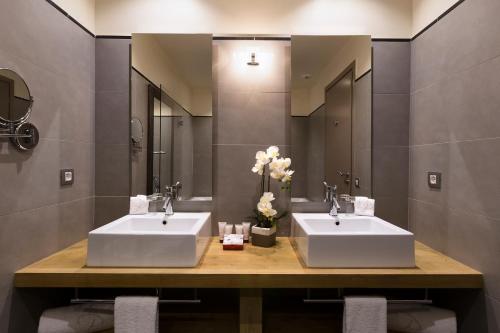 two sinks in a bathroom with two mirrors at Le Pinarello in Sainte-Lucie de Porto-Vecchio