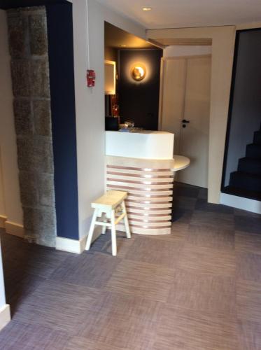 a bar in a room with a stool and a table at La Chaumière Roz-Aven in Pont-Aven