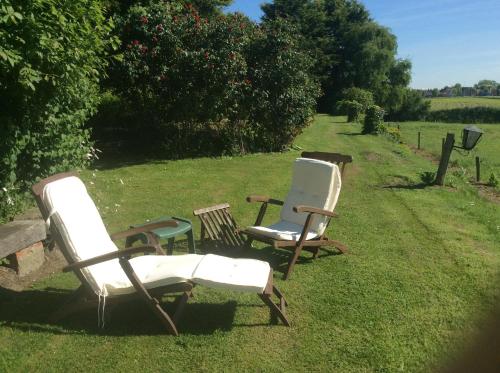 drie stoelen in het gras in een veld bij Hotel De Stokerij in Oudenburg