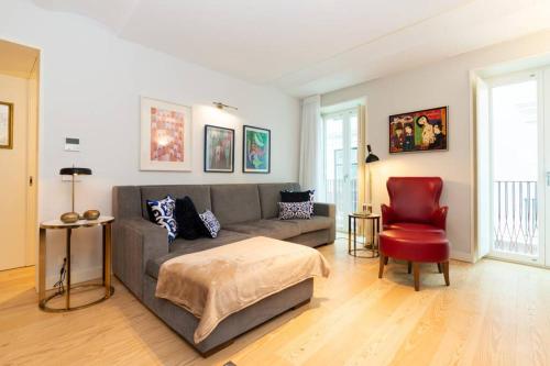 a living room with a couch and a red chair at Bairro Alto Premium Apartment in Lisbon