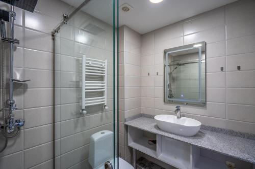 um banheiro com pia e box de vidro em Atrium Exclusive - Ski4Life em Gudauri