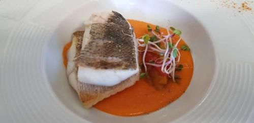 a plate of food with a piece of bread and tomato sauce at Hotel Les Mésanges in Saint-Martin-dʼUriage