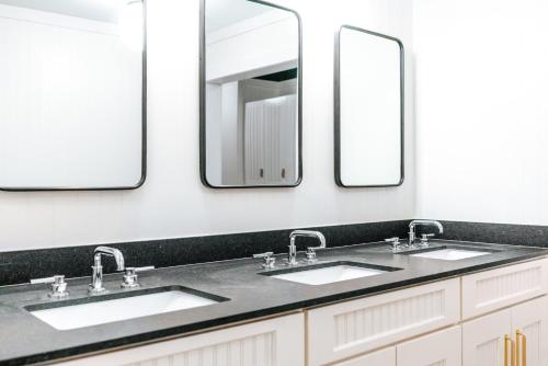 ein Badezimmer mit zwei Waschbecken und zwei Spiegeln in der Unterkunft Cache House in Jackson