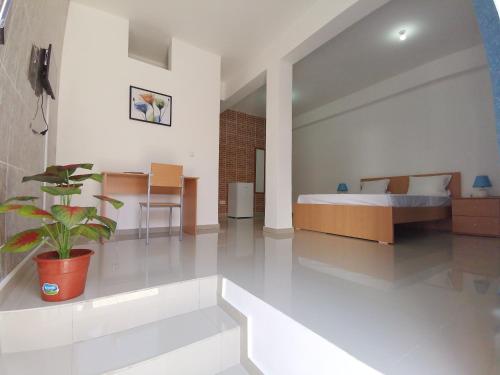 Plateau Bedroom & Chambre - Praia Center 1 في برايا: غرفة نوم مع سرير وزرع الفخار