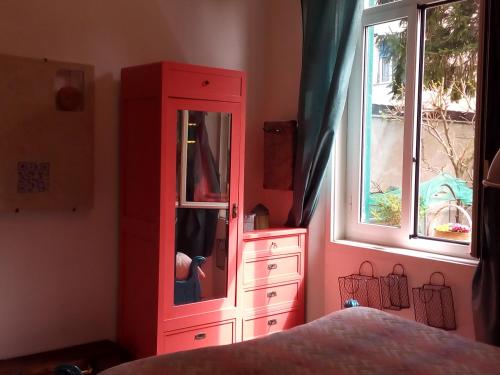 a red cabinet and a dresser in a bedroom at Al Giardino degli Artisti in Cairo Montenotte