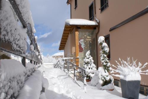 un marciapiede coperto di neve accanto a un edificio di I Narcisi a Roccaraso