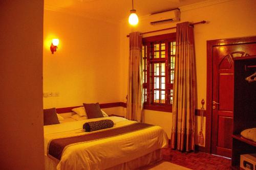 a bedroom with a bed and a window at The Charity Hotel International in Arusha
