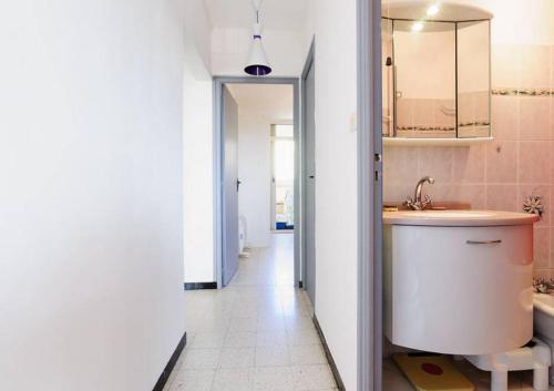 La salle de bains est pourvue d'un lavabo, de toilettes et d'un couloir. dans l'établissement Bel Orizonte, Grand appart 70m2 vue mer, à Ajaccio