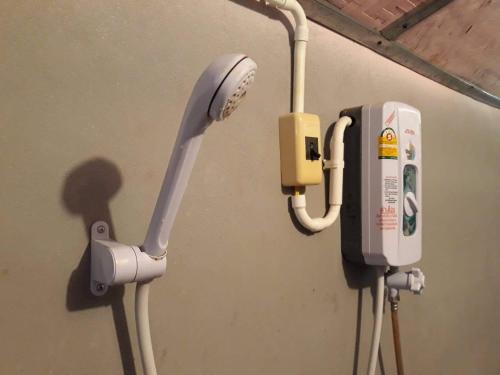 a pay phone and a pump on a wall at KK Hut in Pai