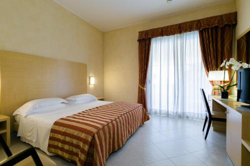 Een bed of bedden in een kamer bij Hotel Continental Wellness & Spa