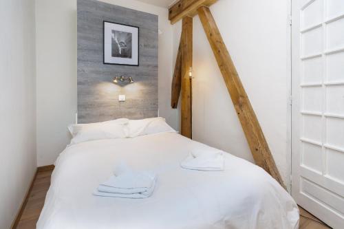une chambre avec un lit blanc avec deux serviettes dessus dans l'établissement Mont Blanc 212 Apartment - Chamonix All Year, à Chamonix-Mont-Blanc