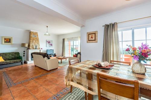 a living room with a table and a couch at Villa da Horta in Alcantarilha