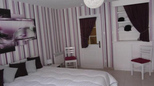Choloy的住宿－Gîte du Gué，一间卧室配有一张床和两把椅子