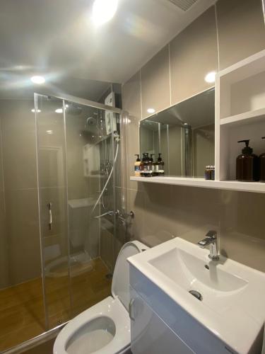 a bathroom with a shower and a toilet and a sink at The Goose House Ubon in Ban Na Khwai