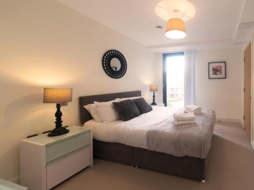 a bedroom with a bed with a lamp and a window at Central Tower Bridge Apartment in London